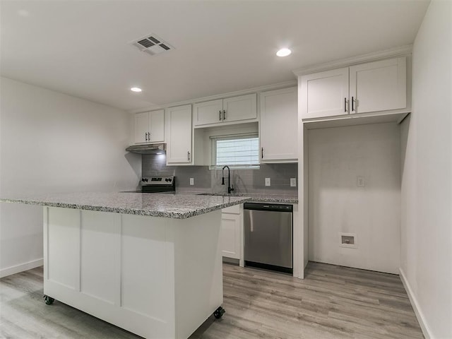 920 N Warren Ave, Oklahoma City, OK 73107 - kitchen featuring stainless steel appliances, a sink, under cabinet range hood, white cabinets, and light wood-type flooring