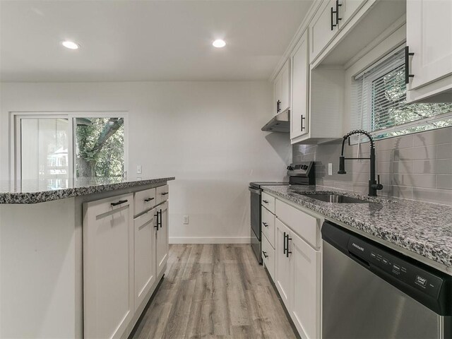 920 N Warren Ave, Oklahoma City, OK 73107 - kitchen featuring stainless steel appliances, a sink, under cabinet range hood, light wood-style flooring, and baseboards