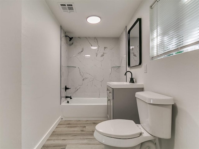 920 N Warren Ave, Oklahoma City, OK 73107 - full bath featuring vanity, toilet, washtub / shower combination, wood finished floors, and baseboards