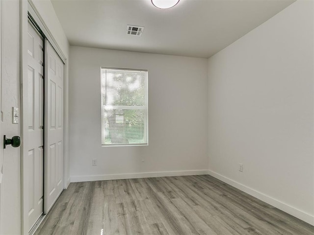 920 N Warren Ave, Oklahoma City, OK 73107 - unfurnished bedroom with light wood-style floors, baseboards, and a closet