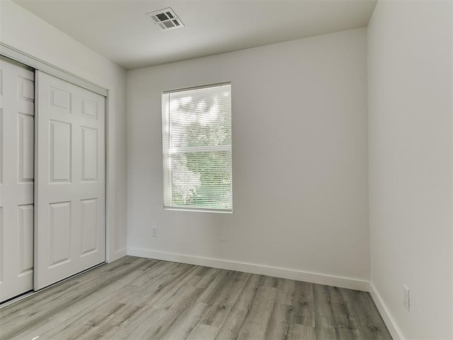 920 N Warren Ave, Oklahoma City, OK 73107 - unfurnished bedroom with light wood-style floors, baseboards, and a closet
