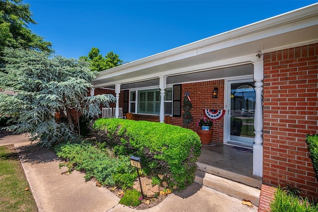 427 Foreman Ave, Norman, OK 73069 - doorway to property featuring brick siding and covered porch
