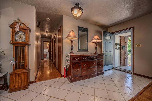 427 Foreman Ave, Norman, OK 73069 - foyer entrance with a textured ceiling, light tile patterned floors, and baseboards