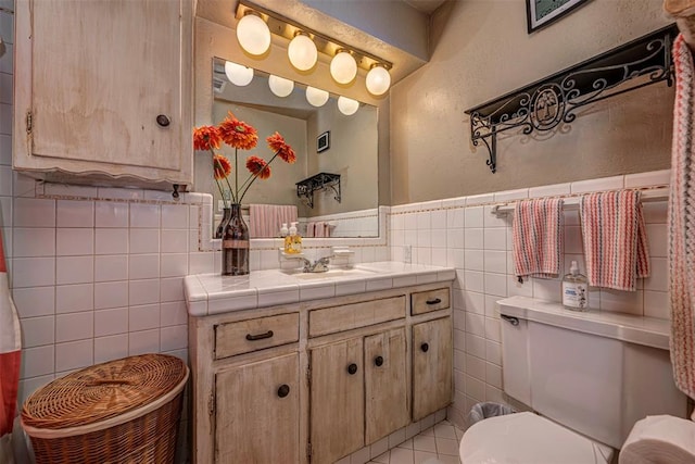 427 Foreman Ave, Norman, OK 73069 - bathroom with tile walls, vanity, toilet, wainscoting, and tile patterned flooring