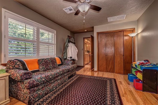 427 Foreman Ave, Norman, OK 73069 - living room with wood finished floors, a textured ceiling, and a ceiling fan