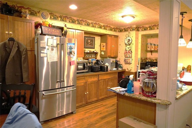 14305 N Pennsylvania Ave Unit 2C, Oklahoma City, OK 73134 - kitchen featuring stainless steel appliances, wallpapered walls, brown cabinetry, dark wood-style flooring, and open shelves