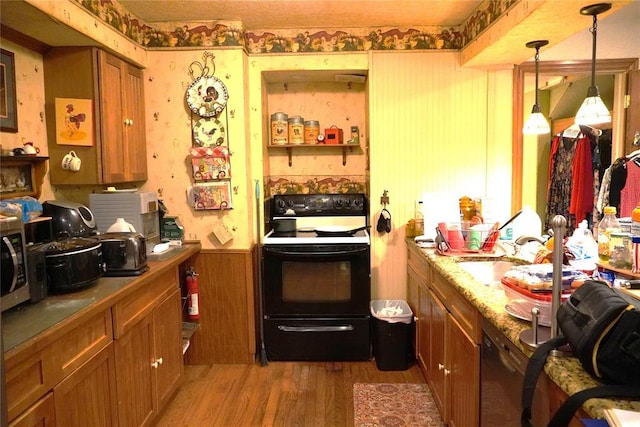 14305 N Pennsylvania Ave Unit 2C, Oklahoma City, OK 73134 - kitchen featuring black electric range oven, wood finished floors, a sink, brown cabinets, and a wainscoted wall