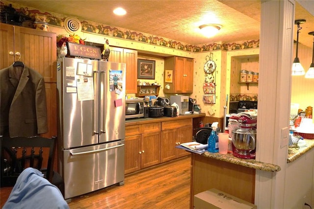 14305 N Pennsylvania Ave Unit 2C, Oklahoma City, OK 73134 - kitchen featuring stainless steel appliances, brown cabinets, dark wood-style flooring, open shelves, and wallpapered walls