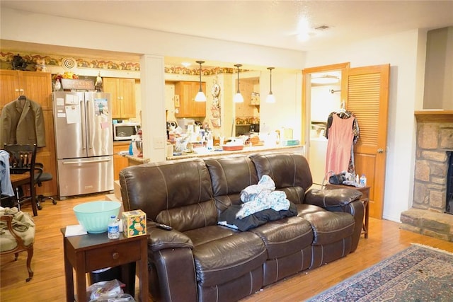 14305 N Pennsylvania Ave Unit 2C, Oklahoma City, OK 73134 - living room with light wood-type flooring and a stone fireplace