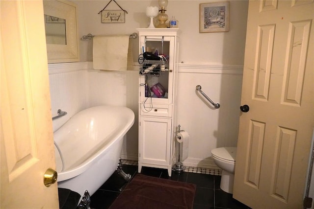 14305 N Pennsylvania Ave Unit 2C, Oklahoma City, OK 73134 - bathroom featuring a freestanding bath, tile patterned floors, wainscoting, and toilet