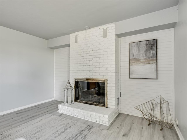 9290 N Hiwassee Rd, Jones, OK 73049 - unfurnished living room with wood finished floors, baseboards, and a brick fireplace
