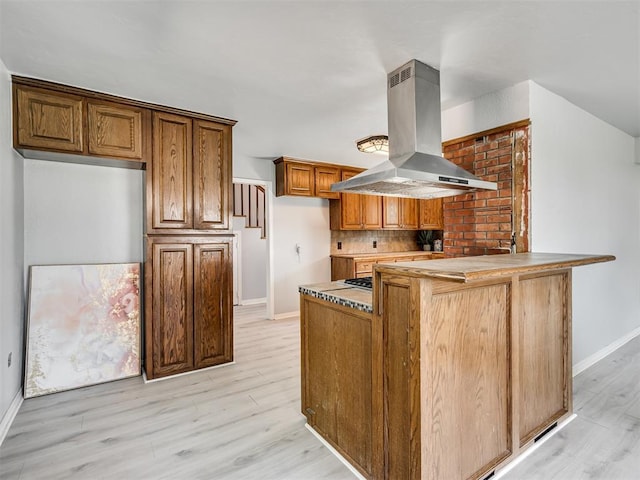 9290 N Hiwassee Rd, Jones, OK 73049 - kitchen with island range hood, a peninsula, baseboards, and light wood finished floors
