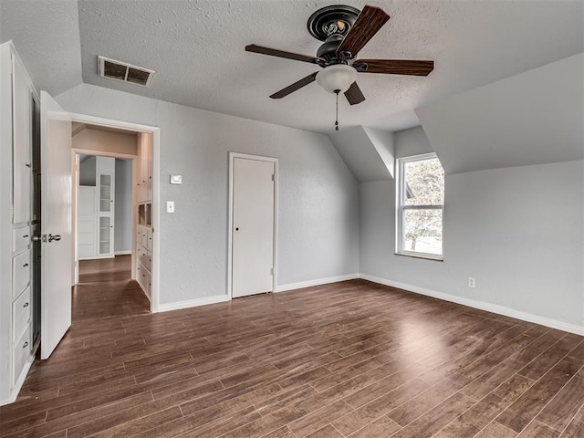 9290 N Hiwassee Rd, Jones, OK 73049 - additional living space with a textured ceiling, wood finished floors, ceiling fan, baseboards, and lofted ceiling