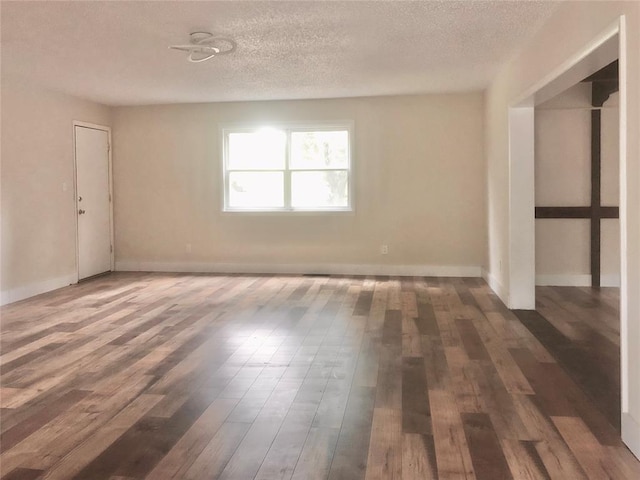 72 Lakeside Dr, Osage, OK 74054 - spare room featuring wood finished floors, a textured ceiling, and baseboards