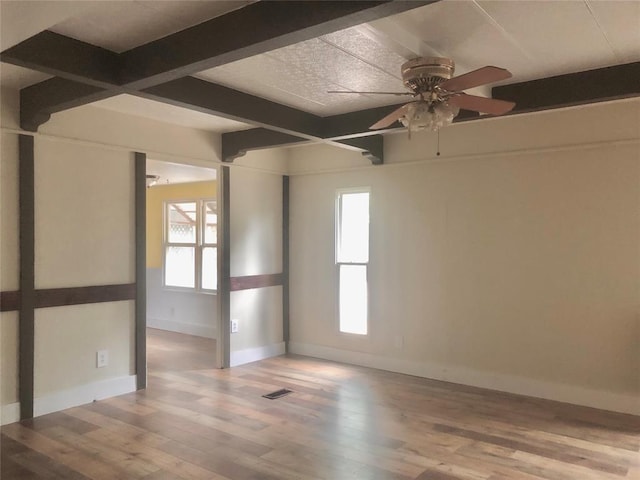 72 Lakeside Dr, Osage, OK 74054 - unfurnished room with beamed ceiling, healthy amount of natural light, baseboards, a ceiling fan, and wood finished floors