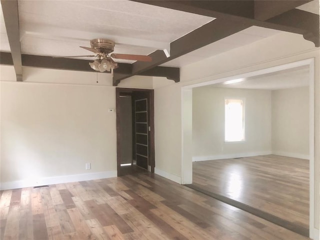72 Lakeside Dr, Osage, OK 74054 - spare room featuring a ceiling fan, beamed ceiling, baseboards, and wood finished floors