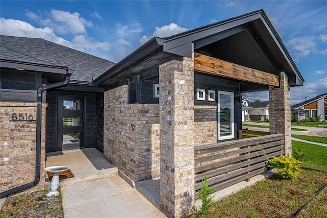 8516 Gibbs Dr, Oklahoma City, OK 73135 - view of exterior entry with roof with shingles and brick siding