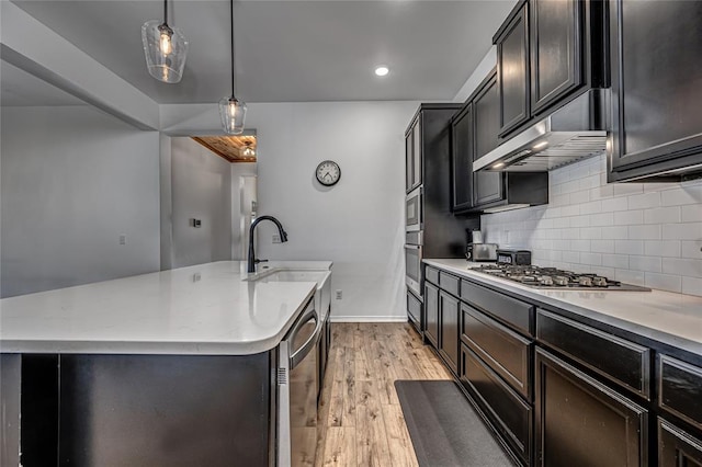 8516 Gibbs Dr, Oklahoma City, OK 73135 - kitchen featuring a sink, stainless steel appliances, under cabinet range hood, an island with sink, and tasteful backsplash