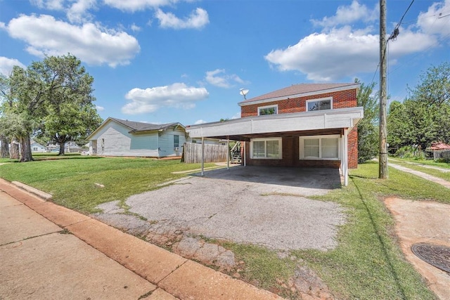 815 Hayes Ave, Clinton, OK 73601 - view of front of home with brick siding, asphalt driveway, and a front lawn