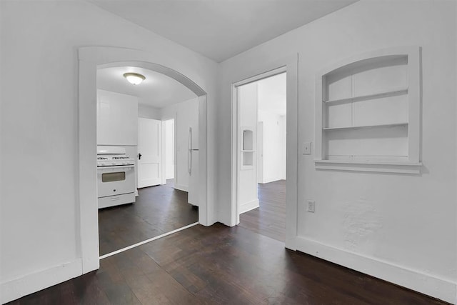 815 Hayes Ave, Clinton, OK 73601 - interior space featuring dark wood finished floors, arched walkways, and baseboards