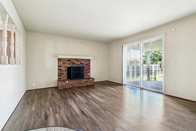 4333 NW 55th St, Oklahoma City, OK 73112 - unfurnished living room featuring wood finished floors, baseboards, and a brick fireplace