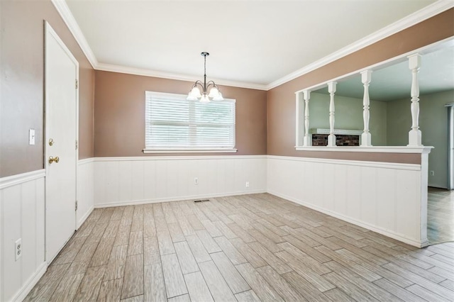 4333 NW 55th St, Oklahoma City, OK 73112 - spare room featuring wood finished floors, wainscoting, a chandelier, and ornamental molding