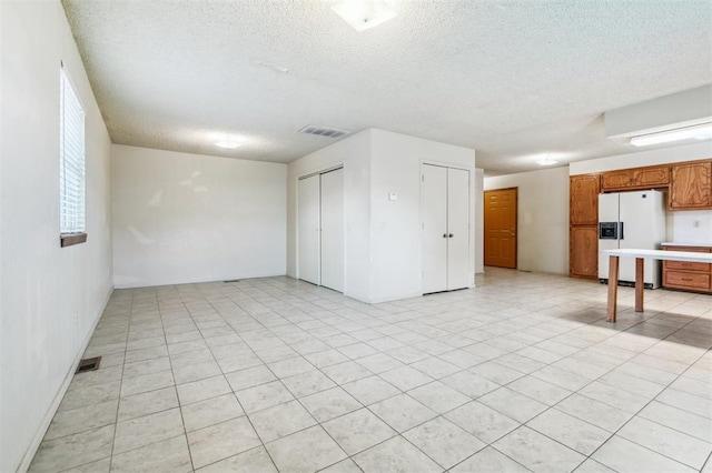 4333 NW 55th St, Oklahoma City, OK 73112 - unfurnished living room with a textured ceiling and baseboards