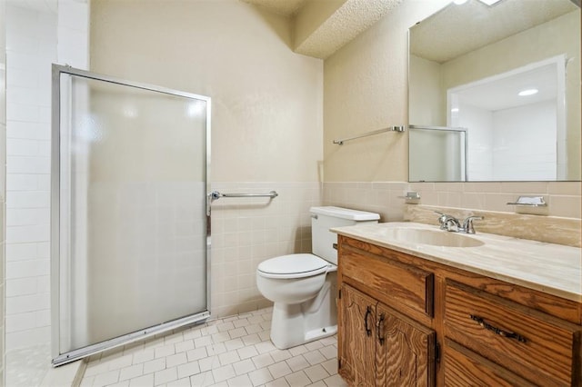 4333 NW 55th St, Oklahoma City, OK 73112 - full bathroom featuring a stall shower, vanity, tile walls, toilet, and tile patterned flooring
