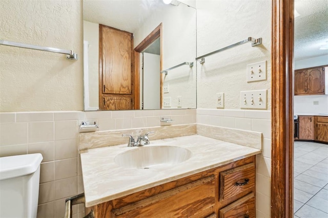 4333 NW 55th St, Oklahoma City, OK 73112 - bathroom featuring vanity, a textured ceiling, toilet, tile walls, and a textured wall