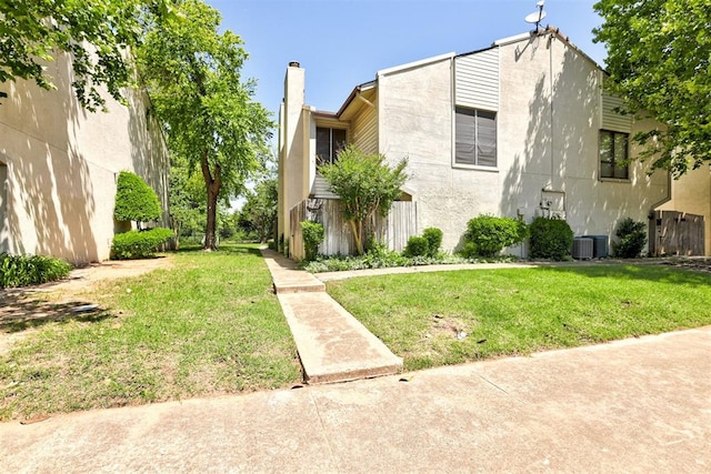 809 Cardinal Creek Blvd, Norman, OK 73072 - view of front of house with a front yard, a chimney, central air condition unit, and stucco siding
