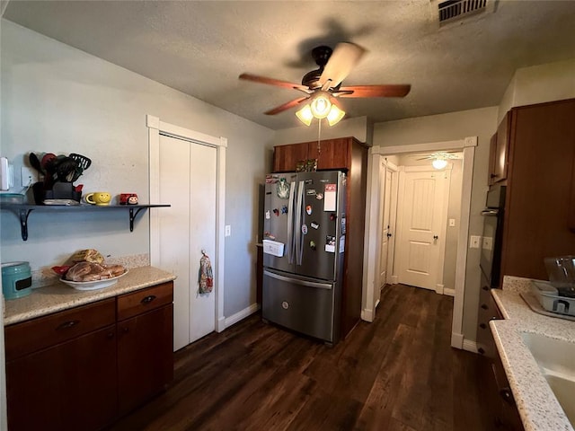 1000 Winnipeg Dr, Yukon, OK 73099 - kitchen featuring freestanding refrigerator, black oven, a ceiling fan, dark wood-type flooring, and light countertops