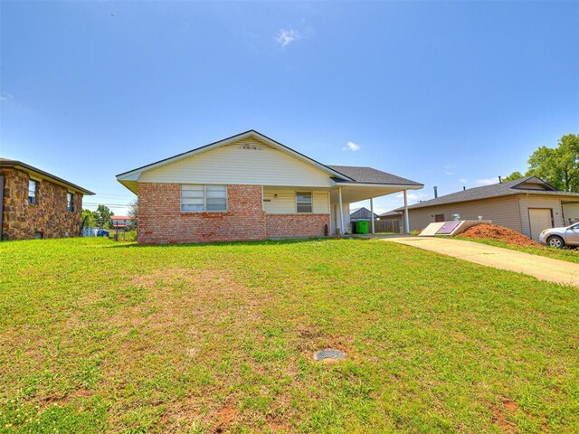 1810 Haynie Ln, Prague, OK 74864 - view of front facade featuring driveway, a front yard, an attached carport, and brick siding