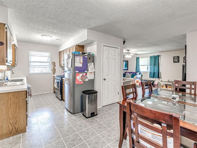 1810 Haynie Ln, Prague, OK 74864 - kitchen with appliances with stainless steel finishes, a sink, light countertops, ceiling fan, and a textured ceiling