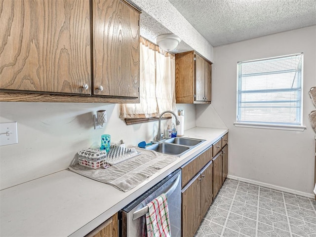 1810 Haynie Ln, Prague, OK 74864 - kitchen with a sink, stainless steel dishwasher, brown cabinetry, light countertops, and a textured ceiling