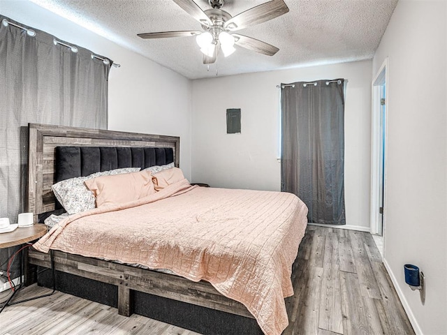 1810 Haynie Ln, Prague, OK 74864 - bedroom with a textured ceiling, wood finished floors, a ceiling fan, and baseboards