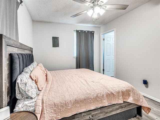 1810 Haynie Ln, Prague, OK 74864 - bedroom with wood finished floors, baseboards, ceiling fan, and a textured ceiling