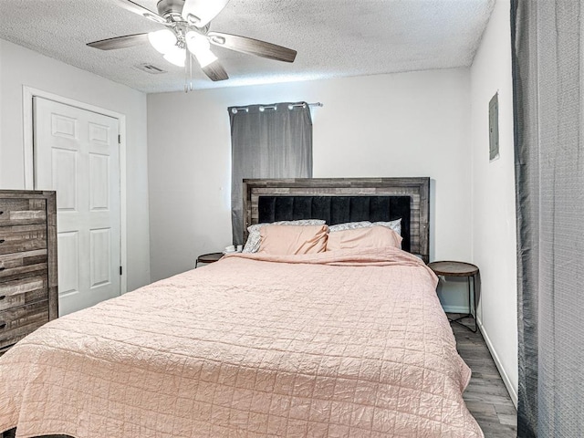 1810 Haynie Ln, Prague, OK 74864 - bedroom with wood finished floors, a textured ceiling, ceiling fan, and baseboards