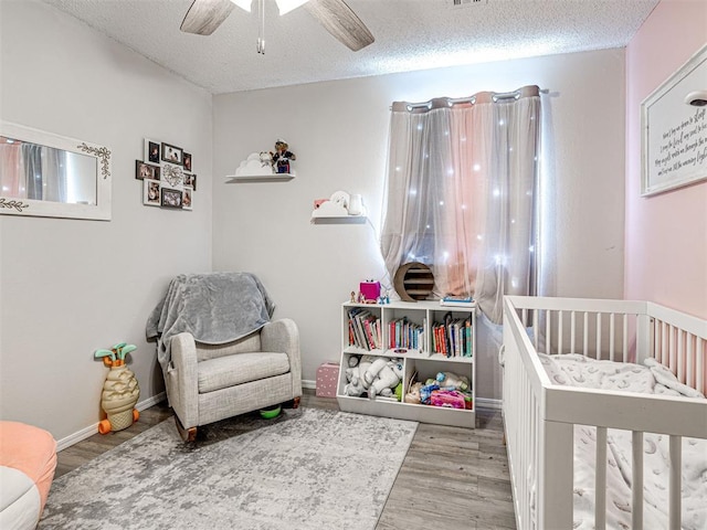 1810 Haynie Ln, Prague, OK 74864 - bedroom with a crib, wood finished floors, a textured ceiling, and ceiling fan