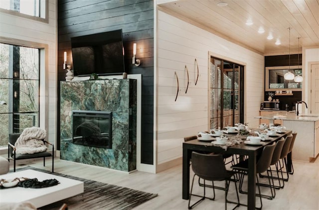 2 Timber Passage Trl, Broken Bow, OK 74728 - dining room with wooden walls, light wood-type flooring, a premium fireplace, and wood ceiling