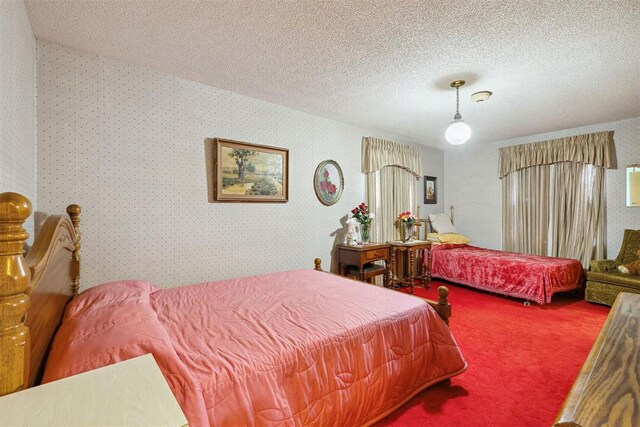 111 W Colorado Ave, Okarche, OK 73762 - bedroom with carpet, a textured ceiling, and wallpapered walls