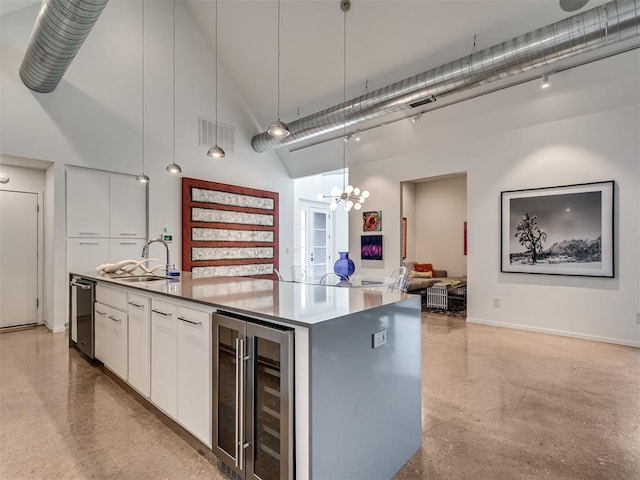 15929 Aparados Way, Edmond, OK 73013 - kitchen with wine cooler, a sink, a high ceiling, a chandelier, and white cabinets