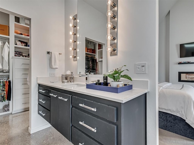 15929 Aparados Way, Edmond, OK 73013 - ensuite bathroom featuring vanity, a spacious closet, speckled floor, and baseboards
