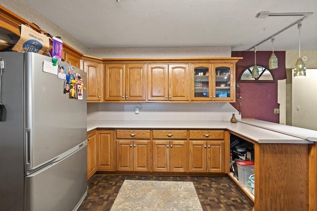 5712 NW 34th St, Oklahoma City, OK 73122 - kitchen with freestanding refrigerator, a peninsula, track lighting, light countertops, and brown cabinets