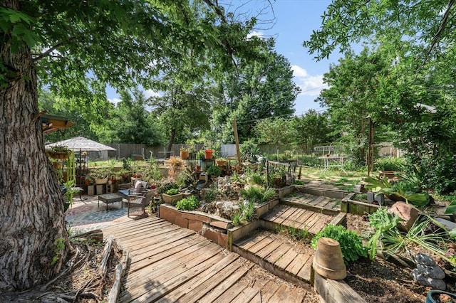 5712 NW 34th St, Oklahoma City, OK 73122 - wooden terrace featuring a fenced backyard, a garden, and view of scattered trees
