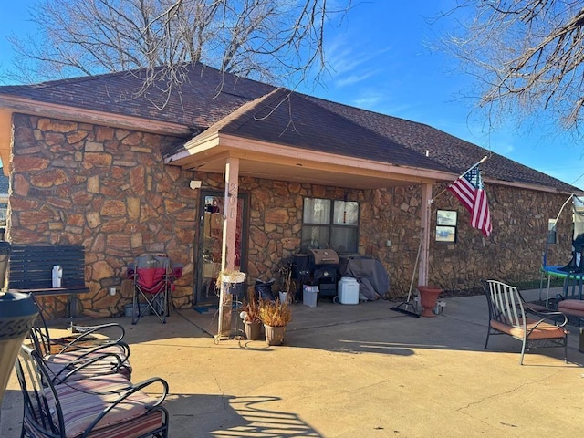 201 N Sheridan Ave, Dover, OK 73734 - back of house with stone siding, a patio area, and a shingled roof