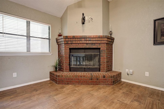1001 Glacier Ln, Edmond, OK 73003 - unfurnished living room featuring a fireplace, baseboards, wood finished floors, and vaulted ceiling