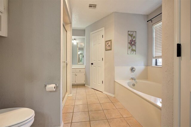 1001 Glacier Ln, Edmond, OK 73003 - bathroom with a bath, tile patterned flooring, toilet, vanity, and baseboards