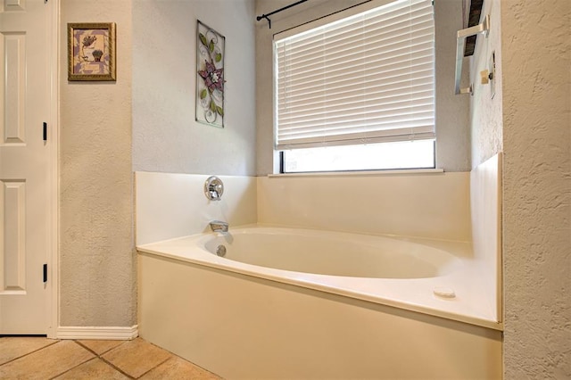 1001 Glacier Ln, Edmond, OK 73003 - bathroom with a textured wall, a bath, and tile patterned floors