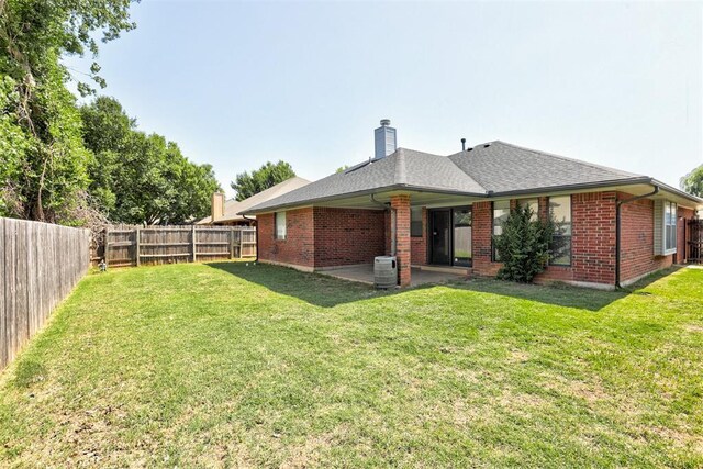 1001 Glacier Ln, Edmond, OK 73003 - back of house with brick siding, a patio, a chimney, and roof with shingles