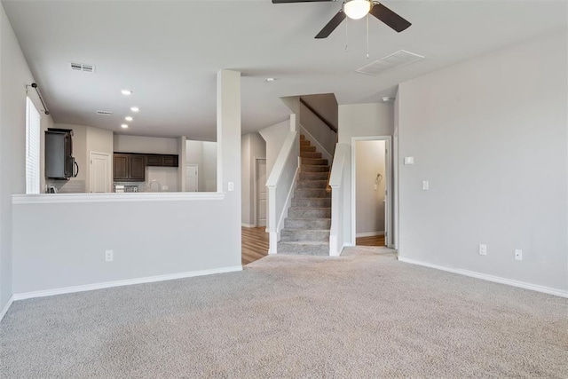 11325 SW 34th Ter, Yukon, OK 73099 - unfurnished living room featuring light colored carpet, stairs, baseboards, and recessed lighting